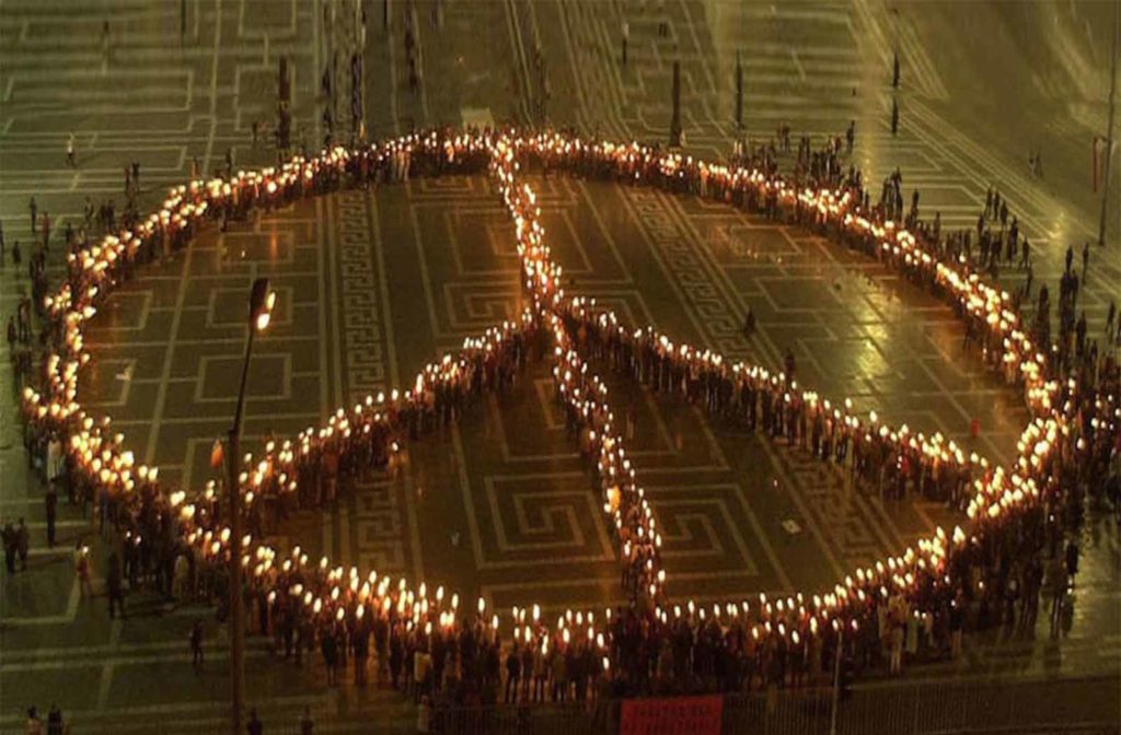 huge human peace sign of candles