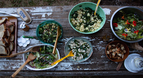 potluck salads on aged wooden table