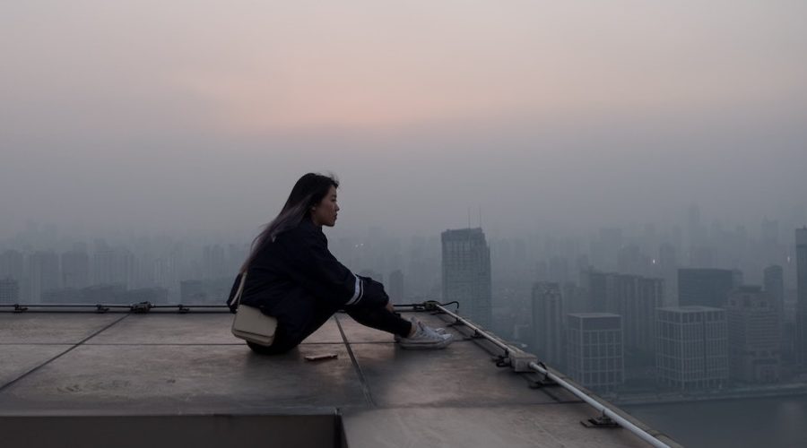 woman gazing at city from rooftop