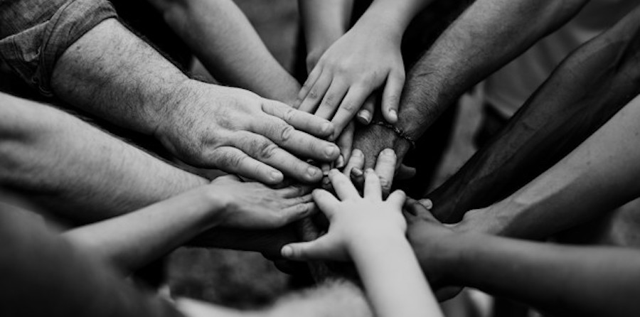 group of people reaching to touch hands